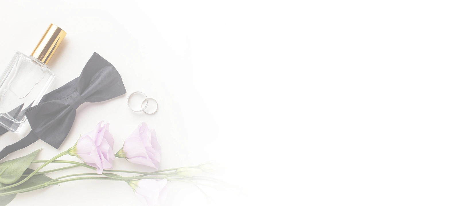 Vue à plat d'articles de mariage comprenant un
                                    nœud papillon noir, deux alliances en argent, un
                                    flacon de parfum et des fleurs violettes sur un
                                    fond blanc.